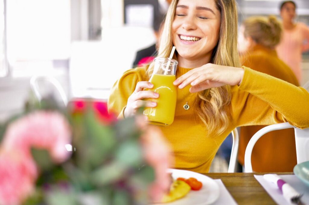 Young Woman Enjoying Juice and Bakery Items from La Belle in Rocky Point, Mexico